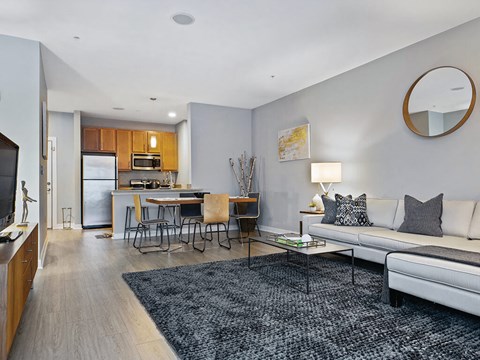 a living room and kitchen with a couch and a table